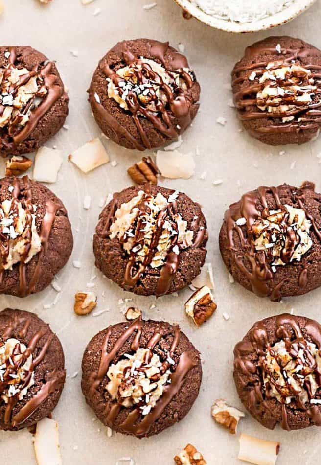 German Chocolate Thumbprint Cookies are all of the things you love about German Chocolate Cake in a cute little thumbprint cookie! A rich, chocolate shortbread with a coconut pecan frosting and drizzled in chocolate!