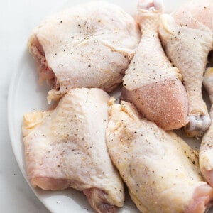 Raw chicken pieces on a white plate