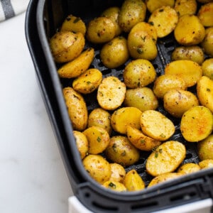 Seasoned, uncooked baby gold potatoes inside of an Air Fryer basket