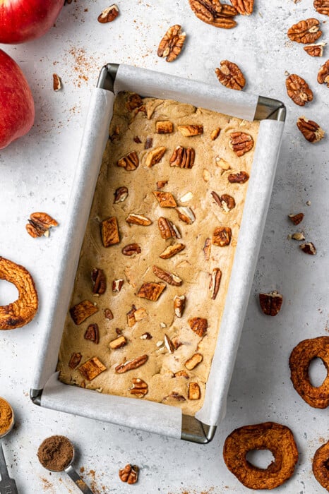 Overhead view of apple pie protein bars topped with pecans in a pan