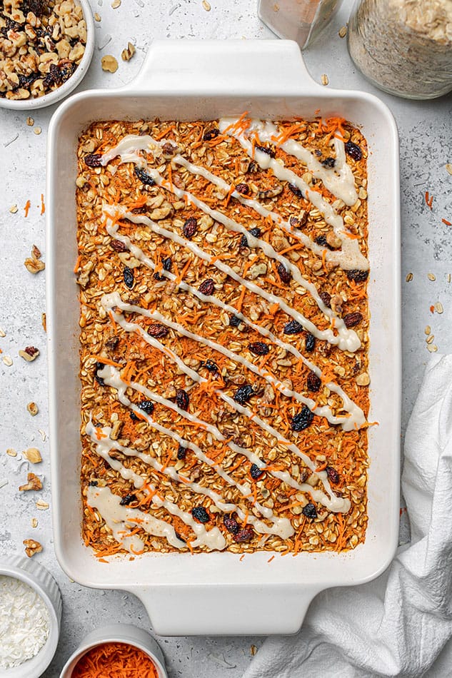 Carrot cake oatmeal in a baking dish after the glaze has been drizzled on top