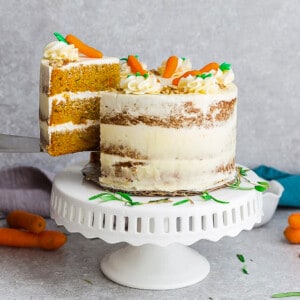 Side view of gluten free Carrot Cake on wooden cake stand