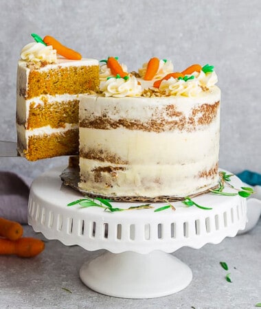Side view of gluten free Carrot Cake on wooden cake stand