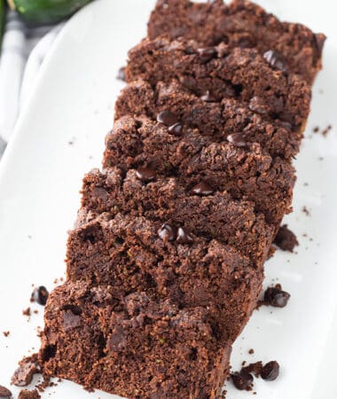 Top view of eight slices of chocolate zucchini bread on a white plate