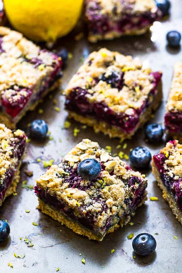 Front view of paleo blueberry crumble bars topped with fresh blueberries.