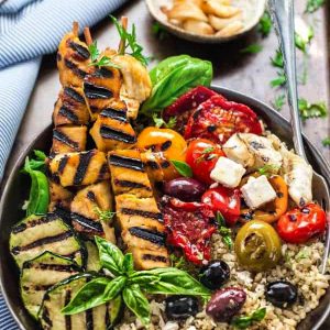 Low Carb Greek Chicken Souvlaki Bowls - the perfect healthy, low carb 30 minute dinner bursting with Mediterranean flavors. Best of all, it's full of fresh bright flavors with tender chicken, grilled vegetables, olives, feta on a bed of cauliflower "rice".