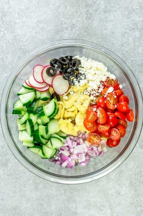 Greek Tortellini Pasta Salad - the perfect side dish to bring to summer potlucks, parties, Memorial Day / Fourth of July grillouts/barbecues. Best of all, it's so easy to make and easy to customize with your favorite toppings and homemade dressing. Perfect for Sunday meal prep and leftovers are delicious for school or work lunchboxes or lunchbowls.