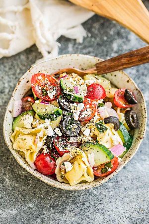 Greek Tortellini Pasta Salad - the perfect side dish to bring to summer potlucks, parties, Memorial Day / Fourth of July grillouts/barbecues. Best of all, it's so easy to make and easy to customize with your favorite toppings and homemade dressing. Perfect for Sunday meal prep and leftovers are delicious for school or work lunchboxes or lunchbowls.