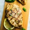A Close-Up Shot of a Juicy Grilled Chicken Breast Beside Herbs and a Slice of Lemon