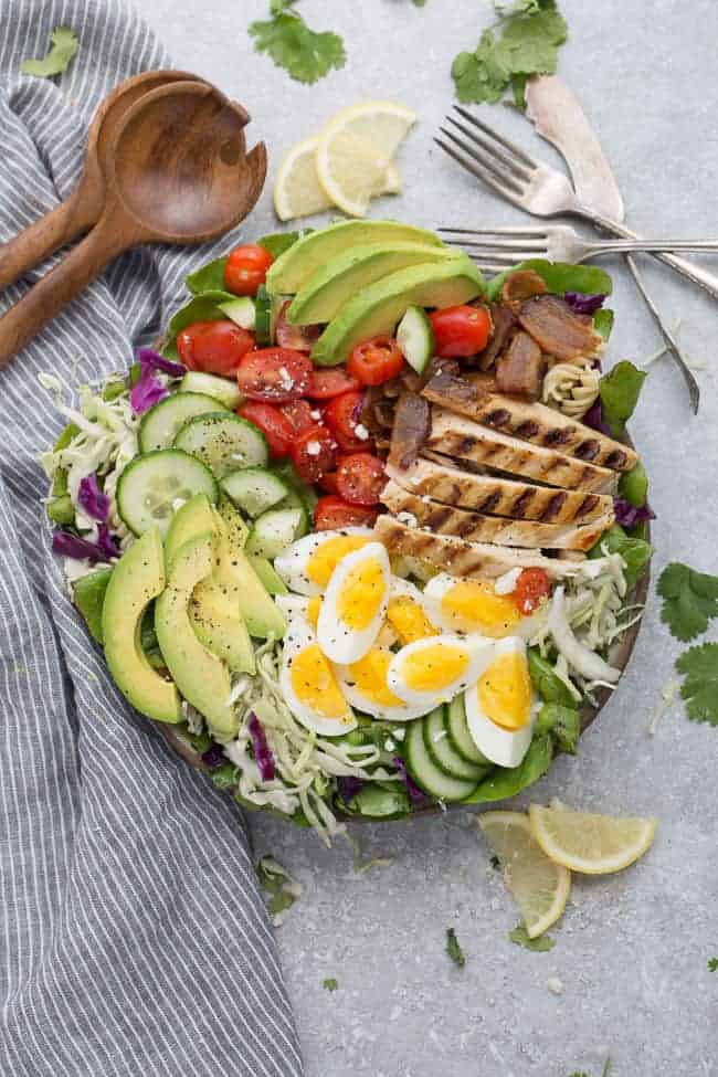 Chicken Cobb Salad has all the classic flavors of the popular favorite with a simple vinaigrette. Made with lettuce, tomatoes, bacon, cucumber, avocado and cheese – perfect for lunch or your next potluck!
