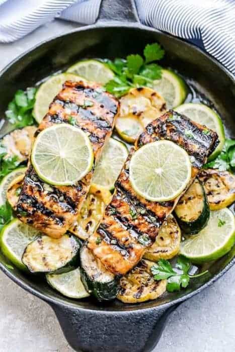 Honey Lime Salmon with zucchini and limes in a skillet