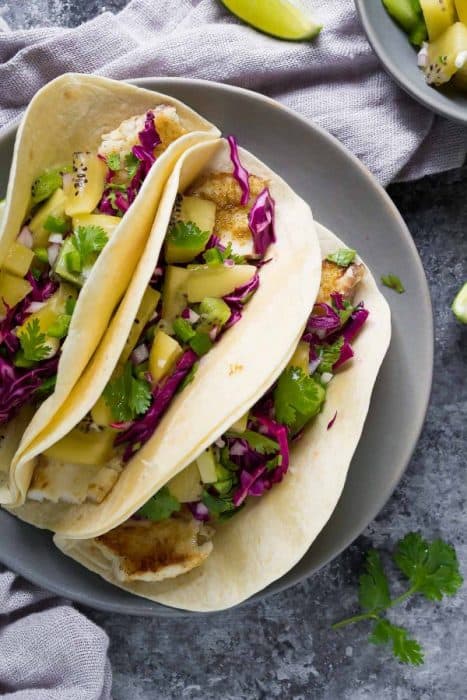 Overhead view of 3 grilled fish tacos on a plate