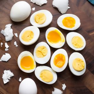 Top view of hard boiled and soft boiled eggs on a wooden cutting board