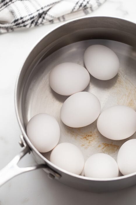 Hard boiled eggs boiling in a stainless steel pot