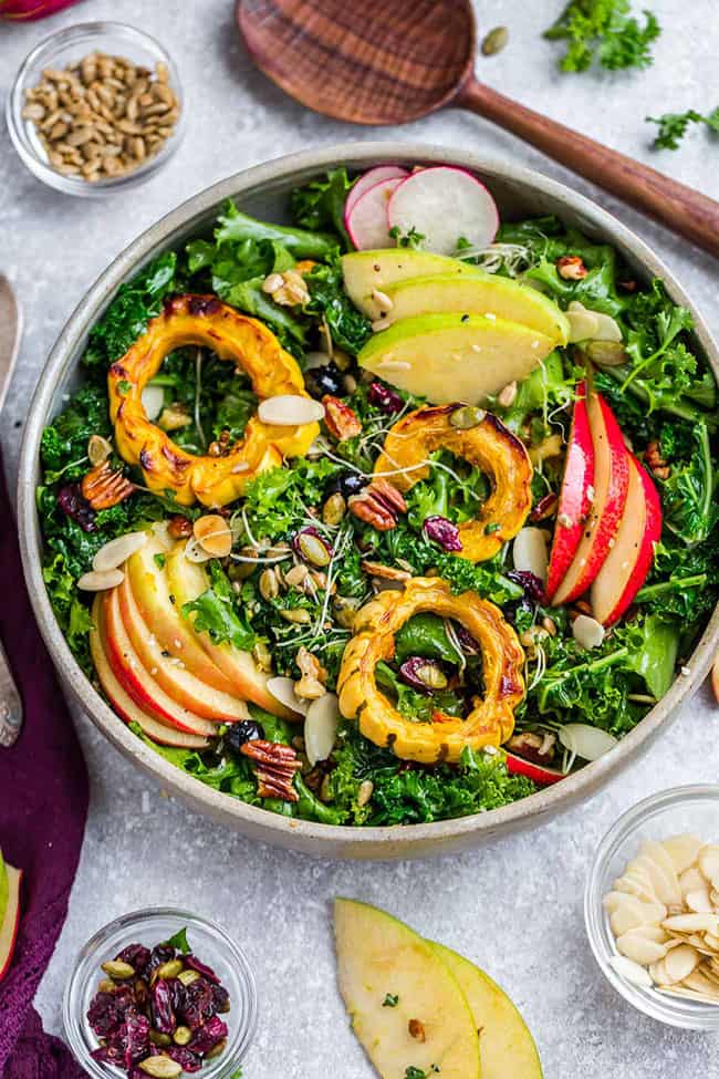 Overhead view of Harvest Kale Salad topped with squash and apples in a serving bowl