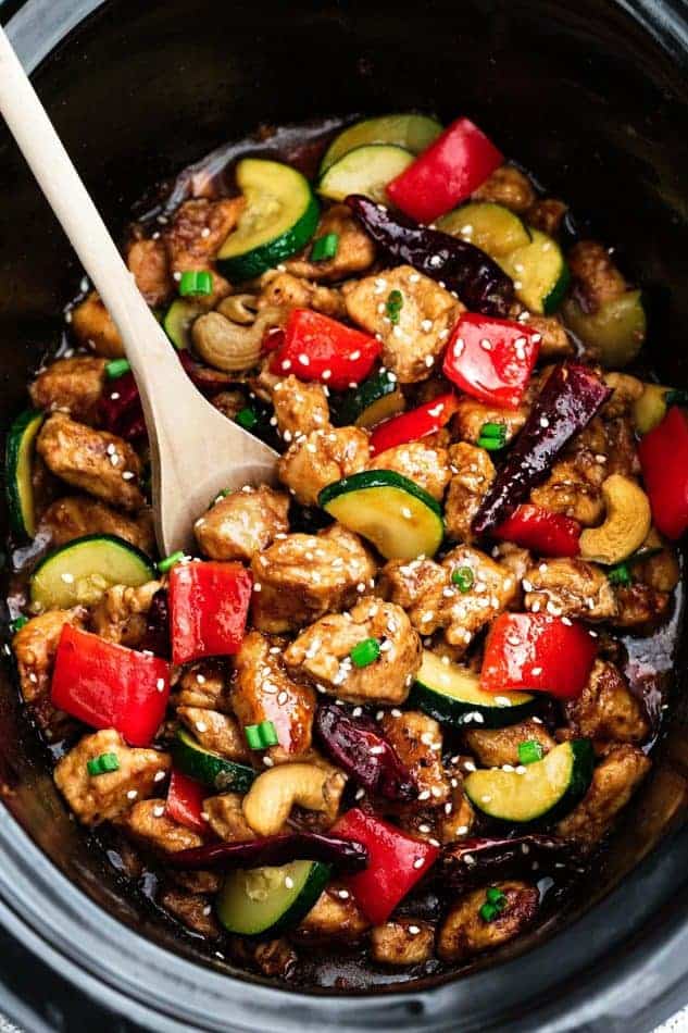 Top view of Slow Cooker Kung Pao Chicken in a crock pot with a wooden spoon