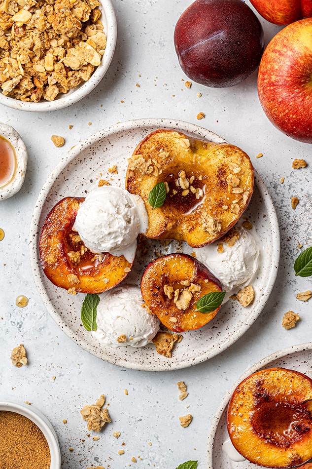 Overhead view of air fryer baked fruit on a plate with vanilla ice cream and granola