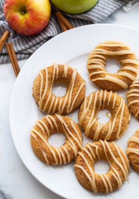 Top view of 6 baked apple cider donuts on a white plate