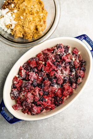 Top view of mixed berry filling for fruit crisp in a blue oval baking pan