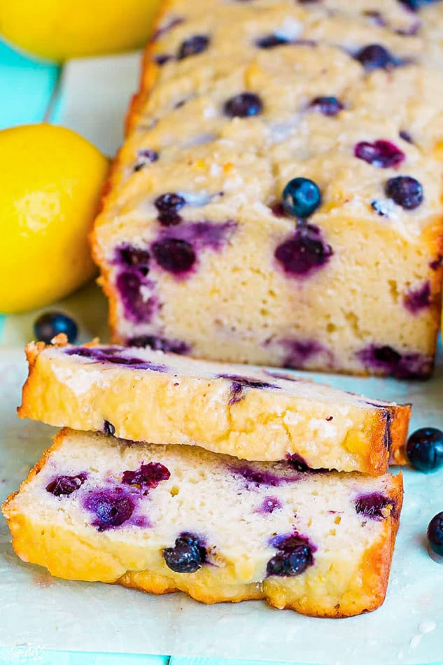 Front view of blueberry bread with lemon on blue surface.
