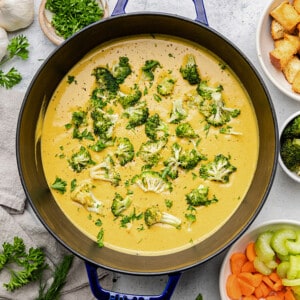 Broccoli cheddar soup in a blue dutch oven / pot