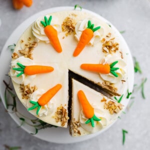 The bird's-eye view of a three-layer carrot cake with one large slice cut off of the cake