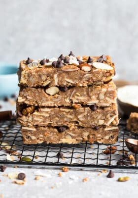 Top view of four stacked chewy granola bars on a cooling rack on a grey background
