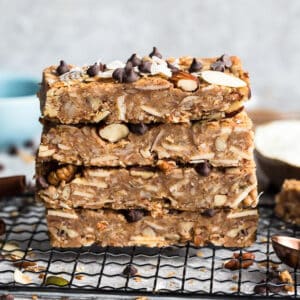Top view of four stacked chewy granola bars on a cooling rack on a grey background