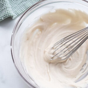 A bowl of icing with a whisk