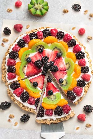 This Healthy Fruit Pizza makes the perfect healthy and extra special breakfast, brunch or dessert. Best of all, it's so easy to make in less than 30 minutes with your favorite fresh fruit, a gluten free granola crust and Vanilla Greek yogurt. Perfect for Mother's Day, Father's Day, Fourth of July, barbecues, potlucks or any other shower or party for spring and summer!