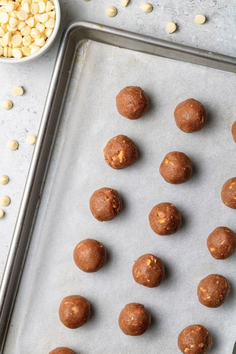 Overhead view of gingerbread truffle balls on a parchment-lined baking sheet