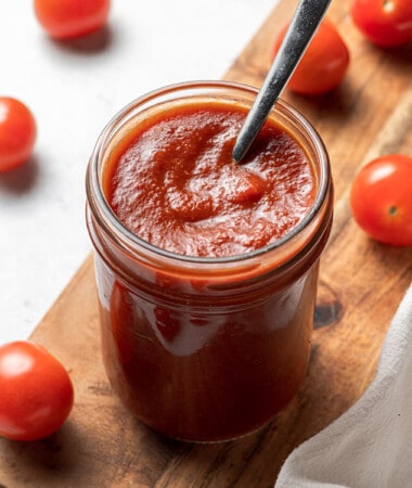 45 degree angle of keto ketchup in a jar with a spoon in the jar