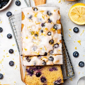 Flat lay of a lemon blueberry loaf with two slices on a wire rack