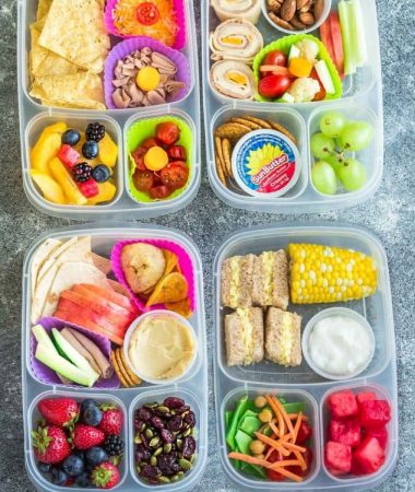 Four school lunch ideas in clear bento lunchboxes on a grey background