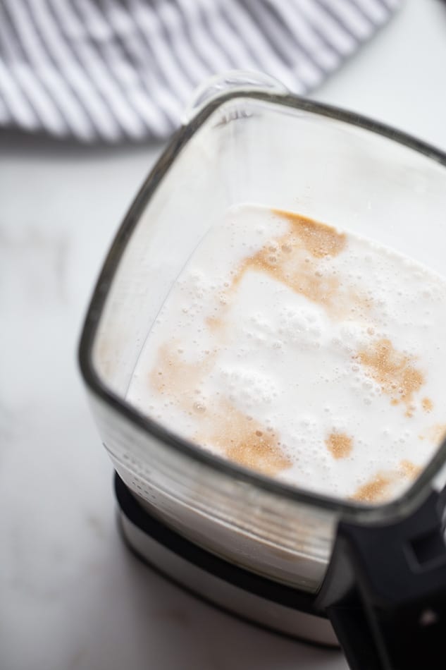 Top view of maple syrup, coconut milk and coconut cream in a blender to make ice cream