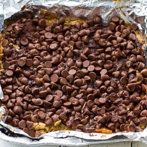A layer of chocolate chips for Pumpkin Oatmeal Bars in a foil-lined pan