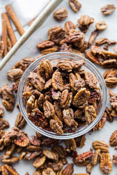 Top view of healthy roasted pecans in a clear bowl on a baking pan