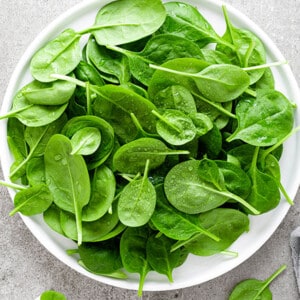 Fresh spinach leaves on white plate. Top view