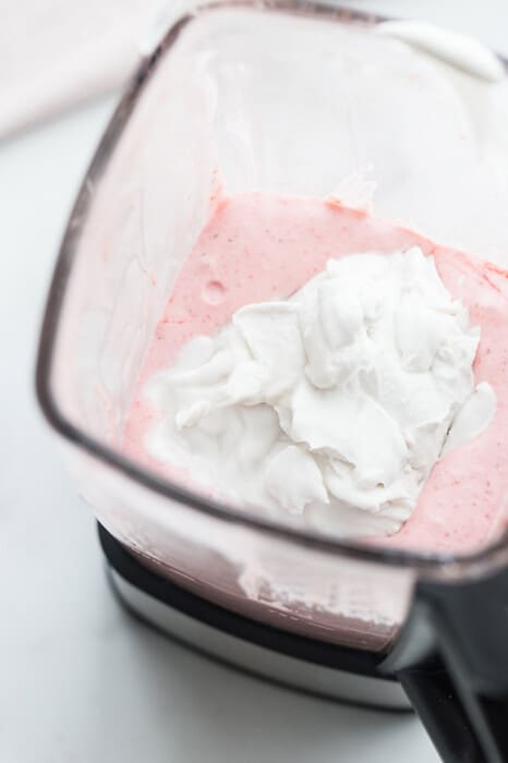 Top view of blended healthy strawberry ice cream in a blender