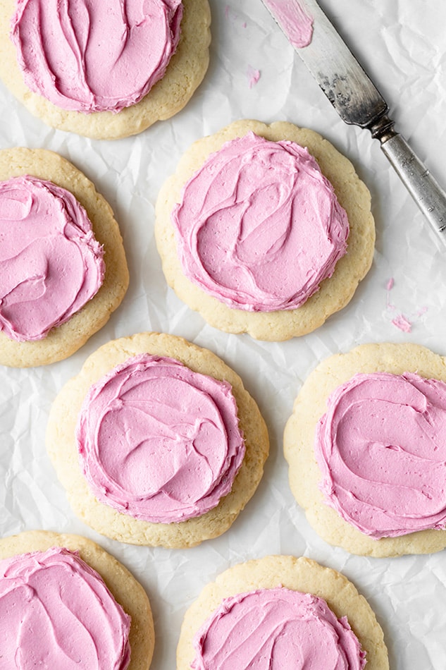 Top view of 7 gluten free sugar cookies with pink icing.