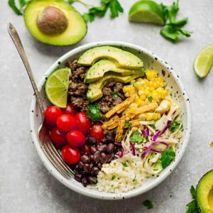 Taco Bowl in a white bowl with corn, tomatoes, beans and avocado