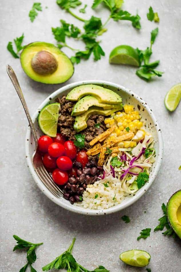Taco Bowl in a white bowl with corn, tomatoes, beans and avocado
