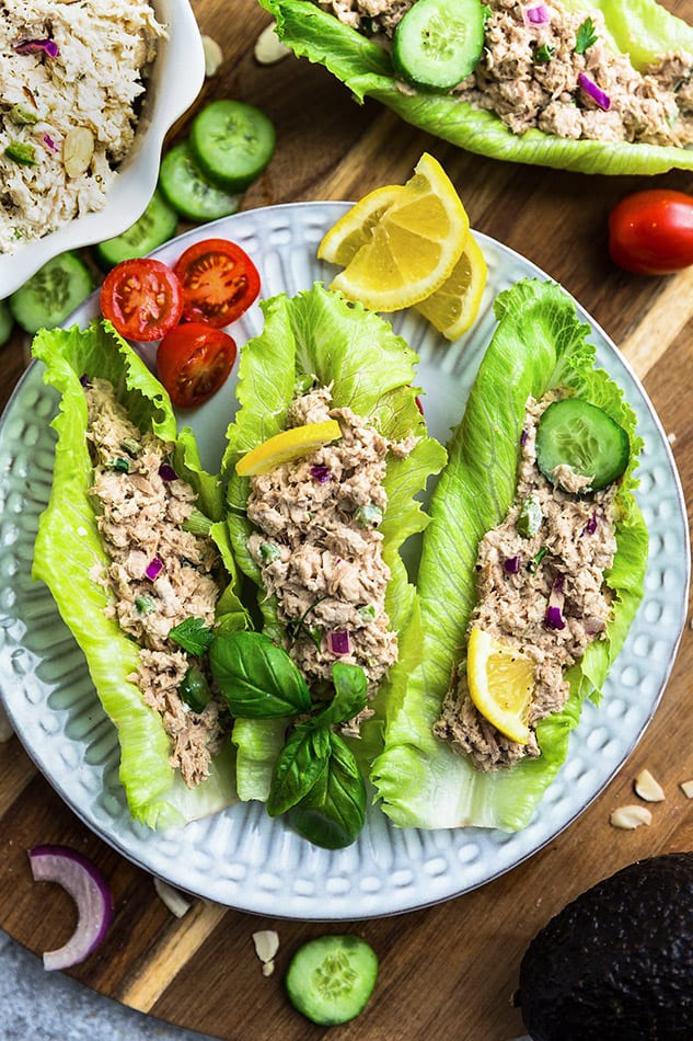 Three lettuce wraps filled with tuna salad on a white plate