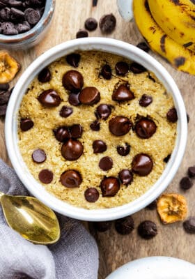 Top view of healthy banana mug cake in a white mug with a golden spoon