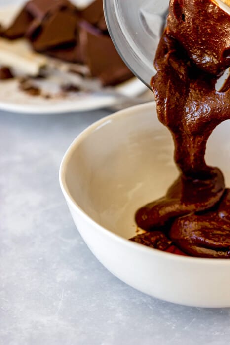Melted chocolate being poured into a white bowl