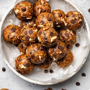 Overhead view of pumpkin energy balls in a paper-lined bowl