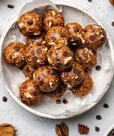 Overhead view of pumpkin energy balls in a paper-lined bowl
