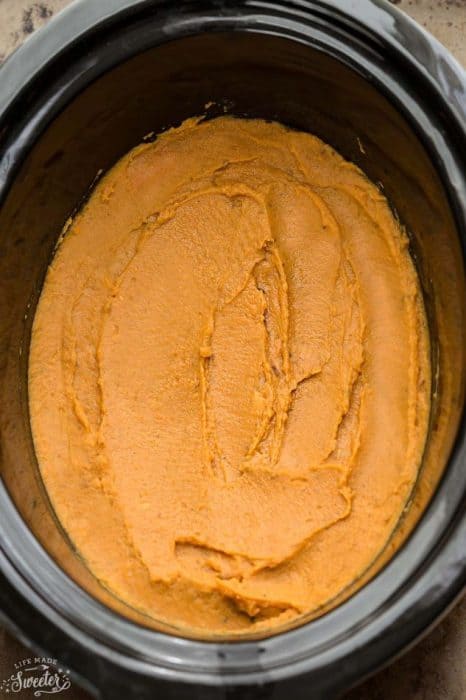 Mashed sweet potatoes spread in a slow cooker