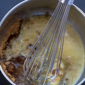 Homemade Caramel Sauce ingredients in a saucepan with a whisk