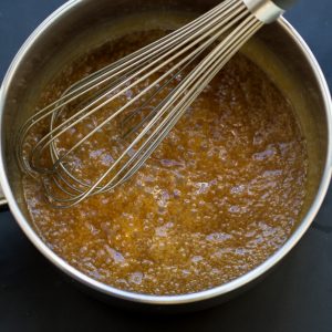 Homemade Caramel Sauce bubbling in a saucepan with a whisk
